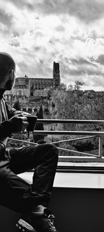 un homme assis sur un train donnant sur un château dans l'établissement L'Incroyable Vue - LOFT - Parking privé gratuit, à Albi