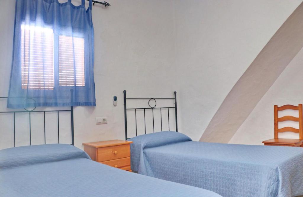 sypialnia z dwoma łóżkami i oknem w obiekcie Apartamento Velarde II w mieście Conil de la Frontera