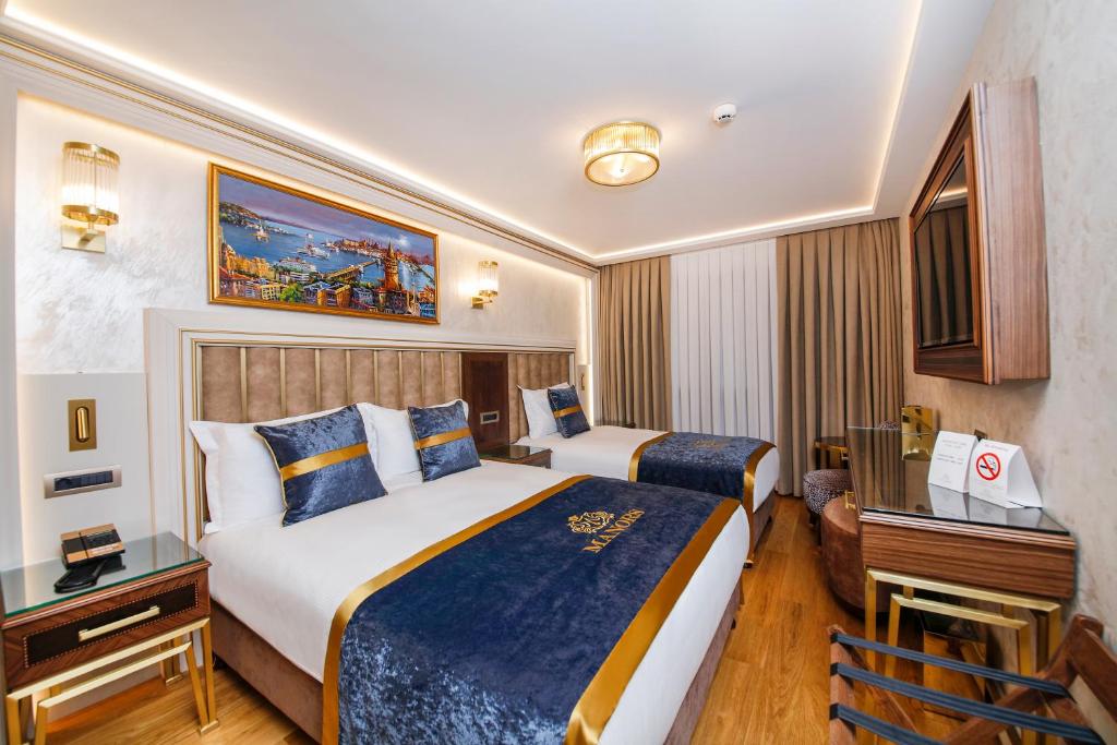 A bed or beds in a room at MANORS HOTEL