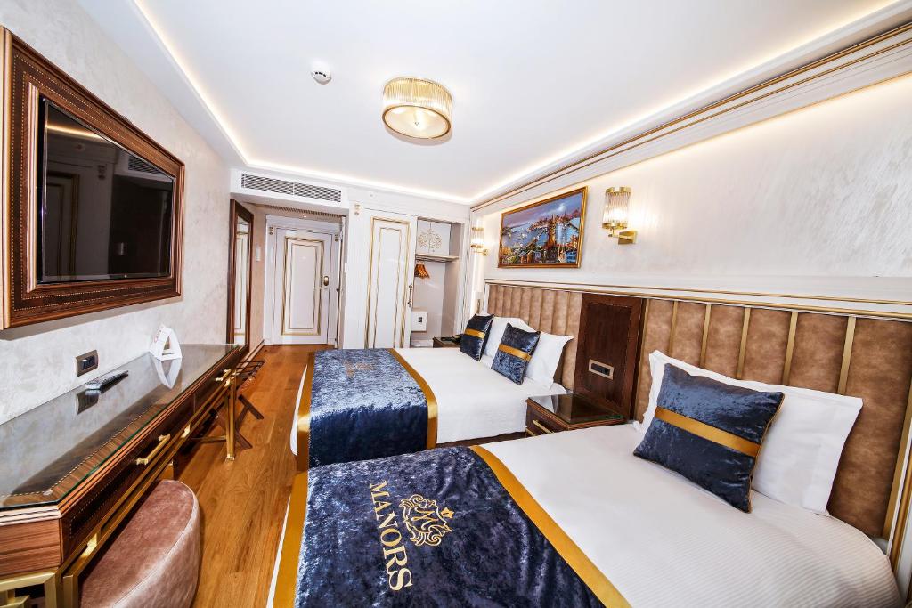 A bed or beds in a room at MANORS HOTEL