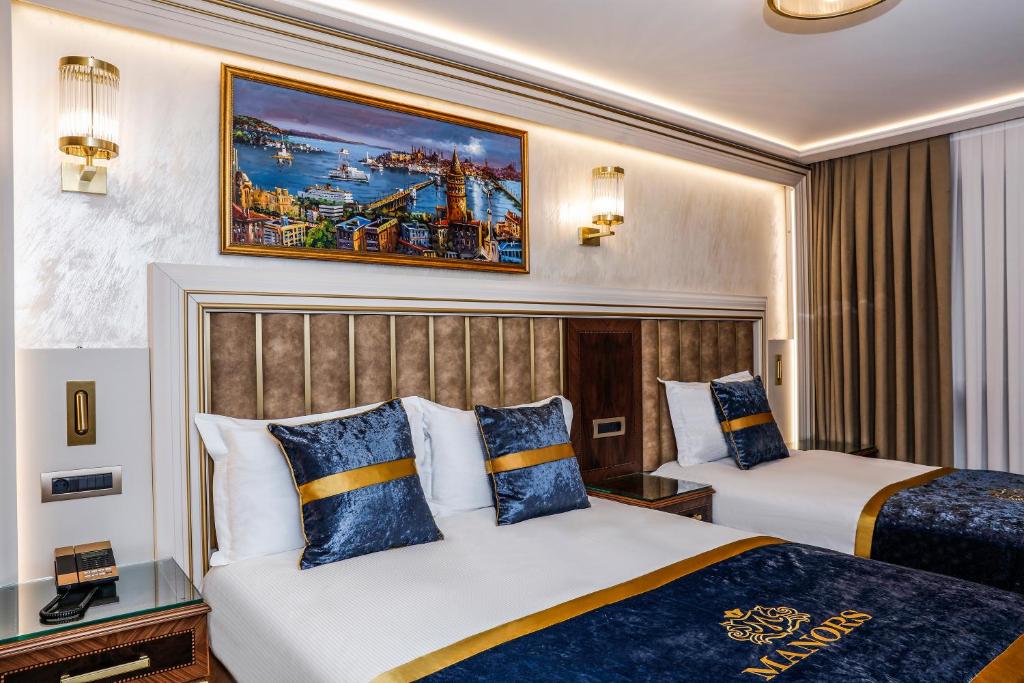 A bed or beds in a room at MANORS HOTEL