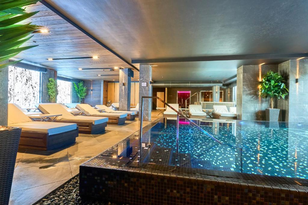 a swimming pool in a living room with couches at Twins Hotel & Spa in Bukovel