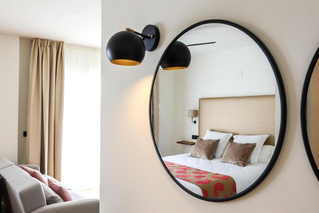a mirror in a hotel room with a bed at FAY Victoria Beach in Rincón de la Victoria