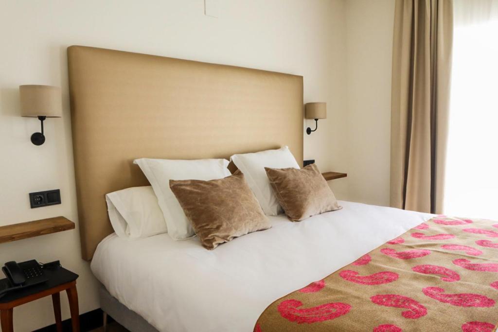 a bedroom with a large white bed with pillows at FAY Victoria Beach in Rincón de la Victoria