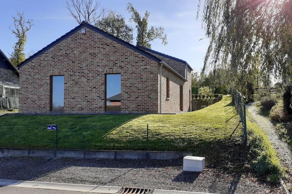 une maison en briques avec une cour herbeuse devant elle dans l'établissement Gîte rural "l'Anseromia", à Dinant