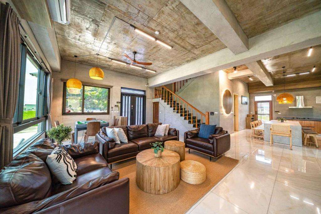 Hsia-ssu-ts'unにある獨棟包棟民宿 宜蘭伍月民宿の革張りのソファとテーブルのあるリビングルーム