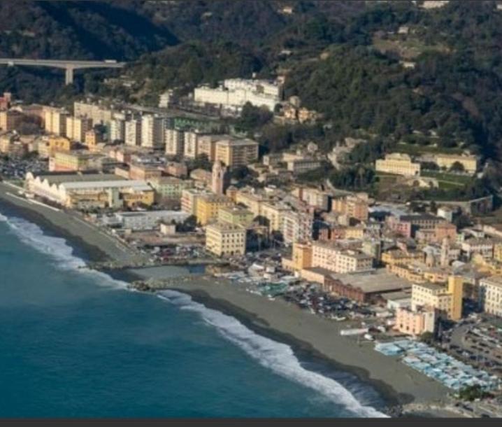 una vista aerea di una spiaggia con edifici e l'oceano di Bilocale Voltri Mare 4 posti a Genova