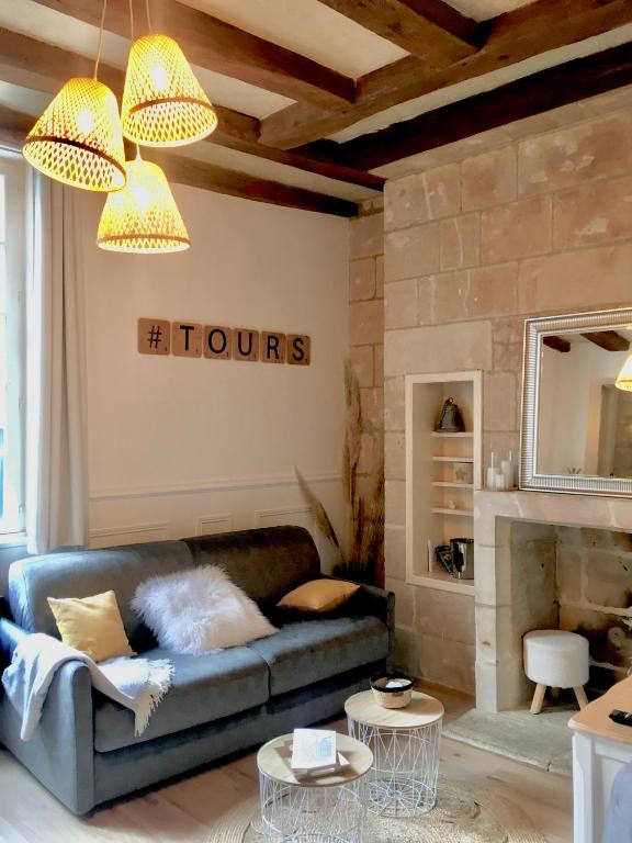 un salon avec un canapé bleu et deux tables dans l'établissement Vieux Tours, Charmant T2 40m2, 4 pers, lumineux, à Tours