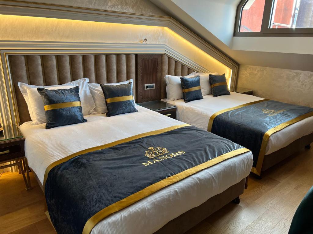 A bed or beds in a room at MANORS HOTEL