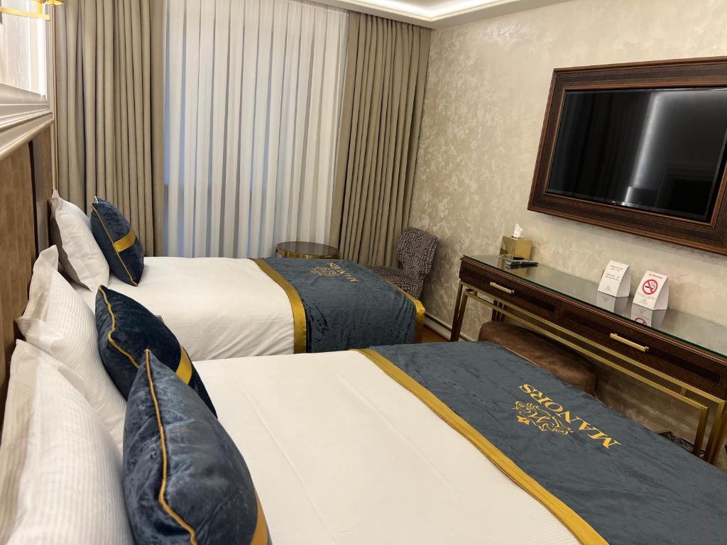 A bed or beds in a room at MANORS HOTEL