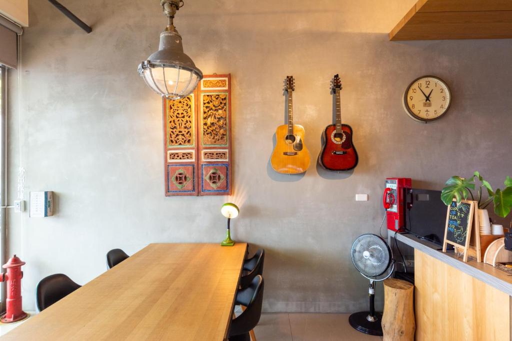 a room with a table and three guitars on the wall at 時光輕旅 Time INN in Hengchun