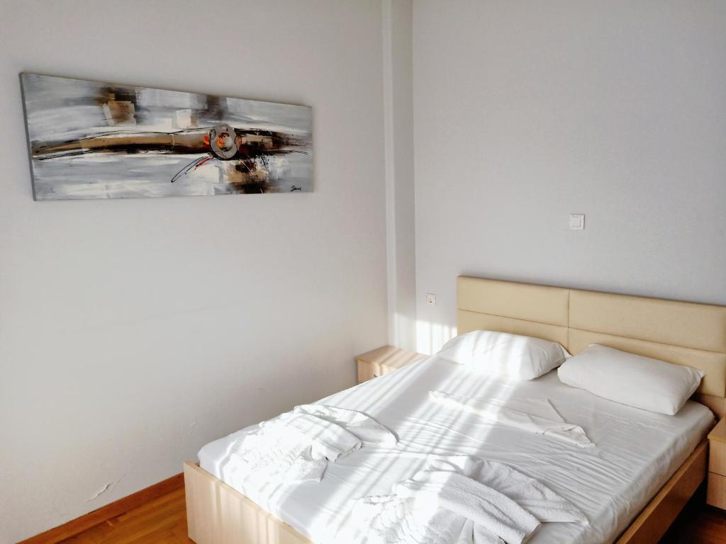 sypialnia z łóżkiem i obrazem na ścianie w obiekcie Siggrou apartment w Atenach