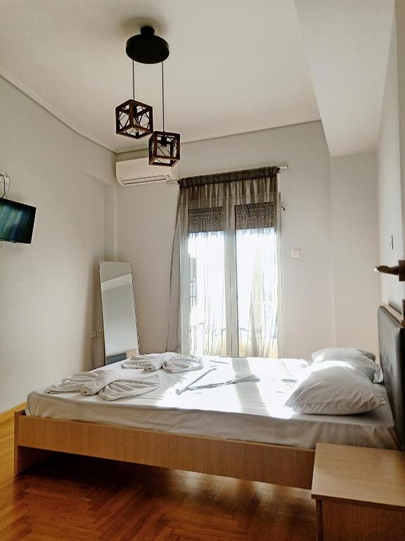 duże łóżko w pokoju z oknem w obiekcie Siggrou apartment w Atenach
