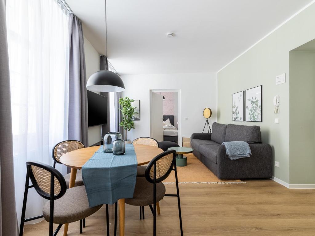 limehome Klagenfurt Goessgasse في كلاغنفورت: غرفة معيشة مع طاولة وأريكة