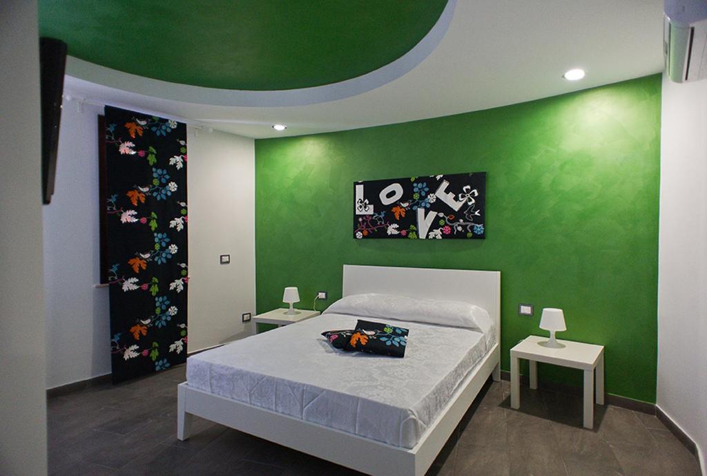 夏卡的住宿－B&B Lido Esperando Sciacca，绿色卧室,配有床和两张桌子