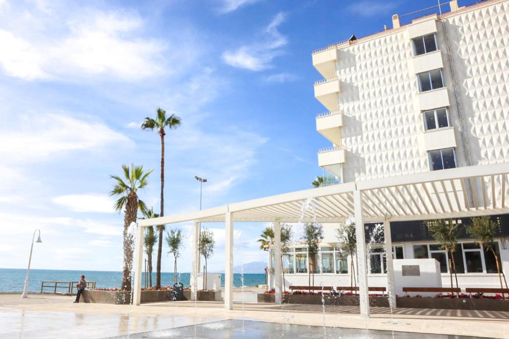 ein Hotel mit Palmen und dem Meer im Hintergrund in der Unterkunft Fay Victoria Beach in Rincón de la Victoria