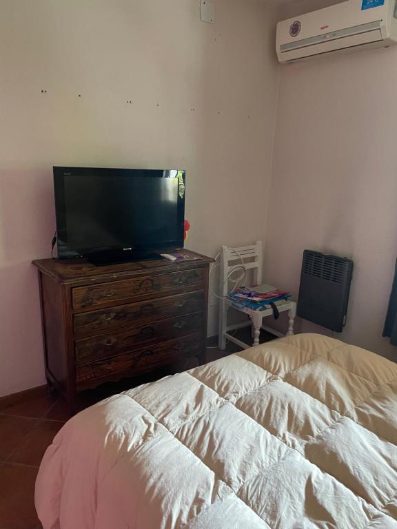 Dormitorio con cama y tocador con TV en Habitación en casa estilo campo en Luján de Cuyo