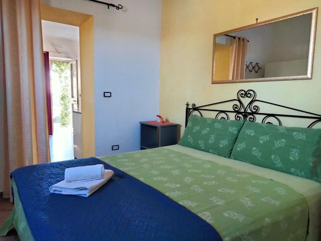 a bedroom with a bed with blue sheets and a mirror at Salento nel cuore in Racale