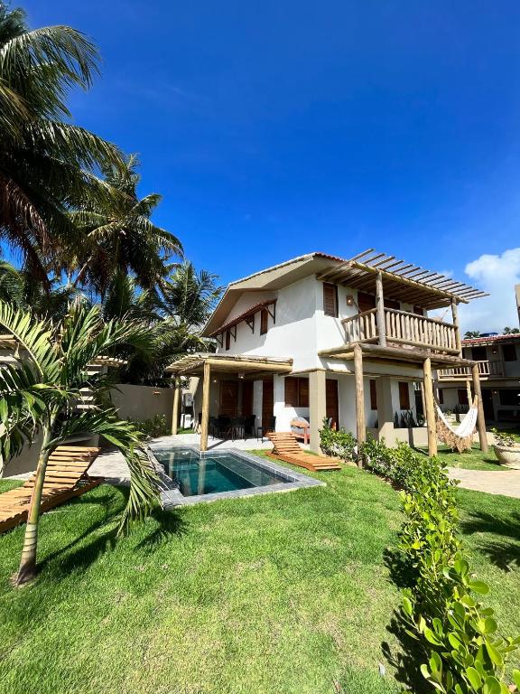 a house with a swimming pool in the yard at Condomínio Praias de Maragogi & Casas Deluxe in Maragogi