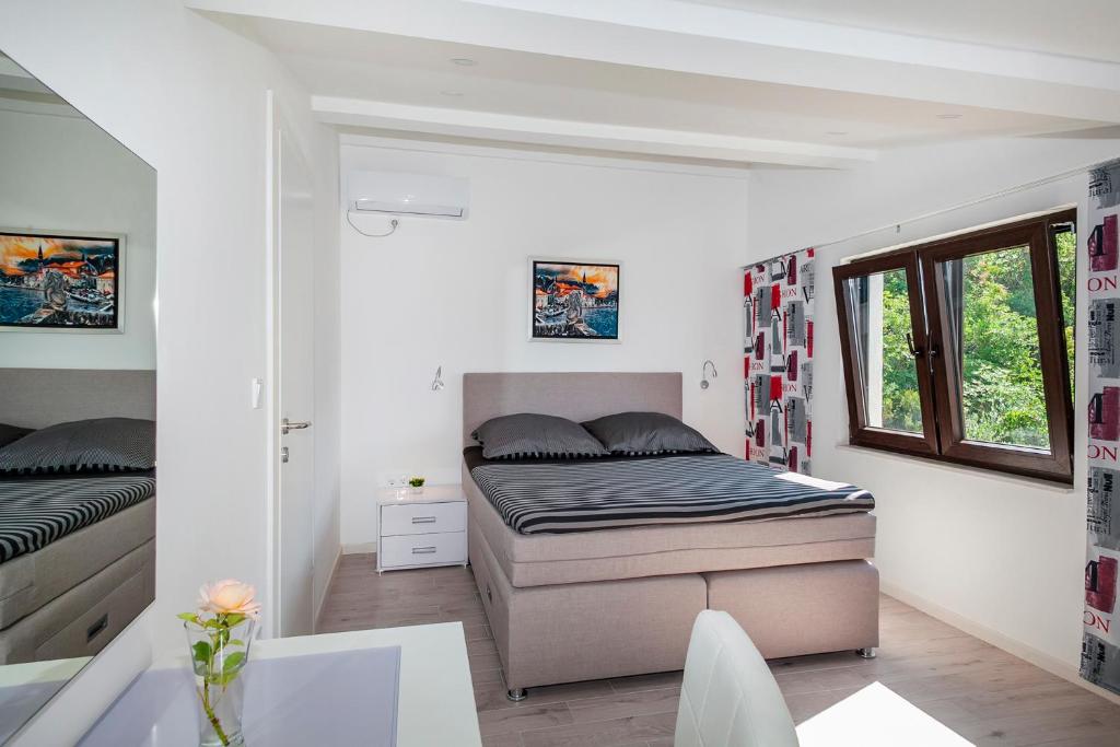 a small bedroom with a bed and a window at Villa Mona 2 in Budva