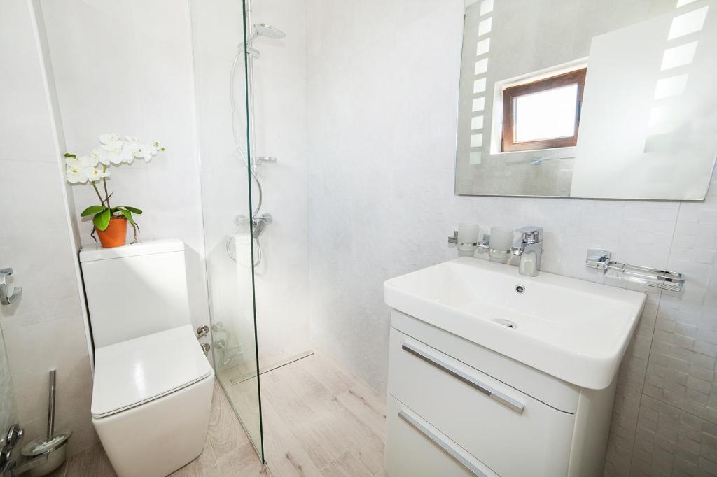 a white bathroom with a sink and a mirror at Villa Mona 2 in Budva