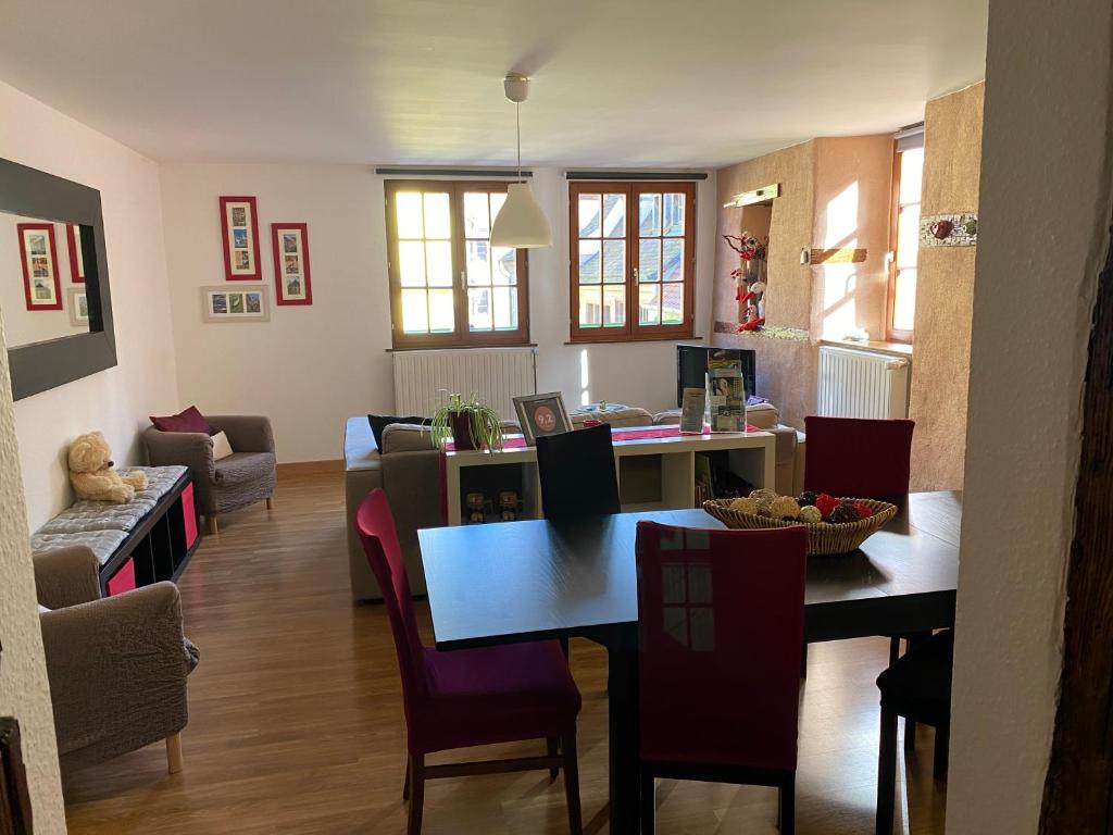 un soggiorno con tavolo da pranzo e sedie di Gîte 4* Duplex centre historique Riquewihr a Riquewihr
