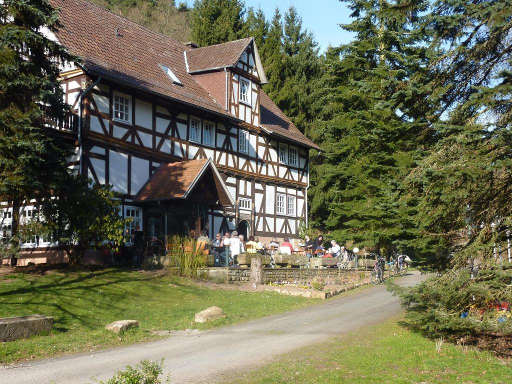 a large house with people sitting outside of it at Hof Guttels Waldgasthof Ferienpension in Rotenburg an der Fulda