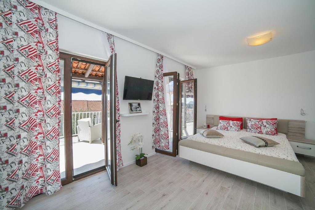 a bedroom with a large bed and a balcony at Villa Mona 2 in Budva