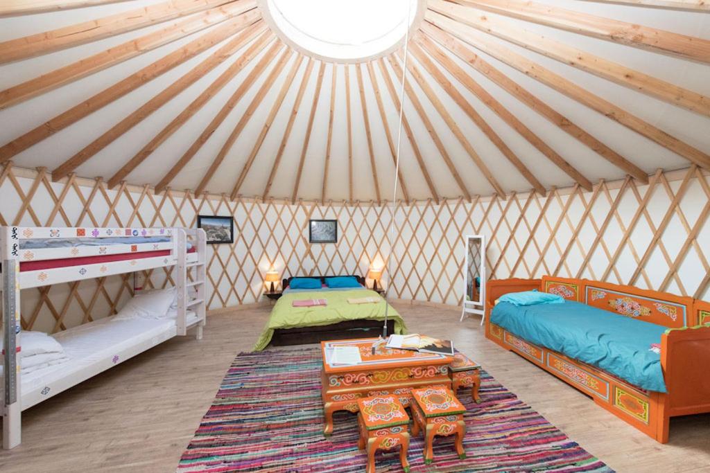 um quarto com duas camas e uma mesa numa tenda em Eco-hôtel et Yourtes du Mercantour em Guillaumes