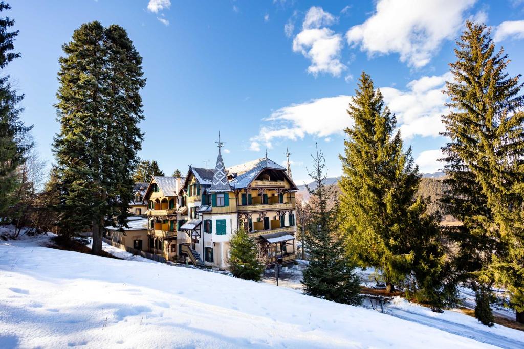 une grande maison sur une colline dans la neige dans l'établissement Hotel Salegg, à Alpe di Siusi