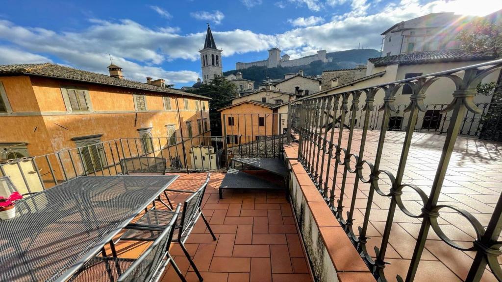 uma varanda com uma mesa e bancos numa rua da cidade em Terrazza Duomo With Spectacular Views La Posterna, 5 mins walk no02 em Spoleto