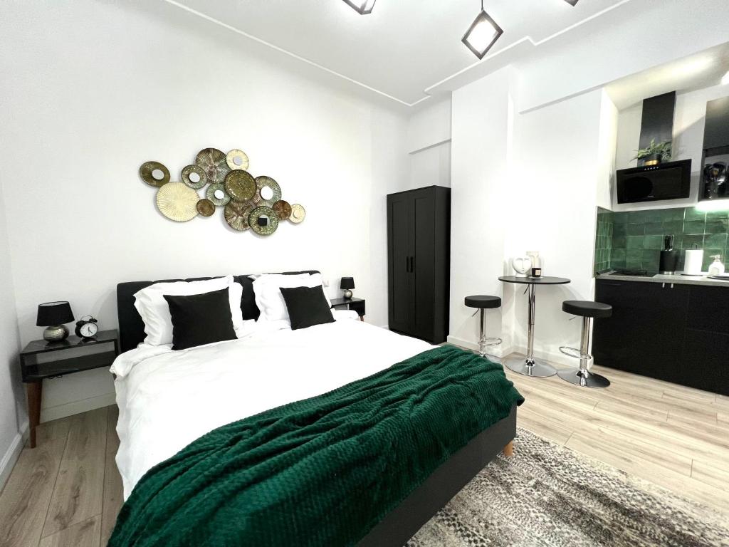 a bedroom with a large bed with a green blanket at Green Spot - Premium Studio - Sanador Victoriei in Bucharest