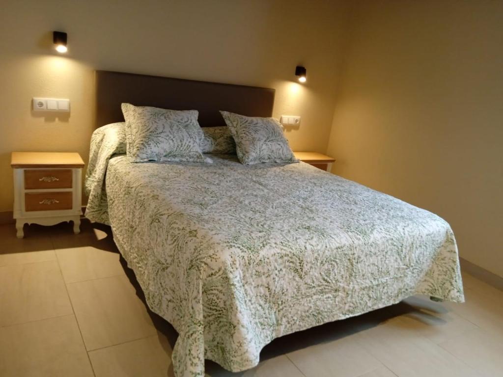 um quarto com uma cama grande e 2 almofadas em O Lar do Alecrín em Friol