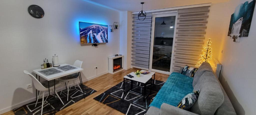 a living room with a couch and a table at Apartman Panorama in Bjelašnica