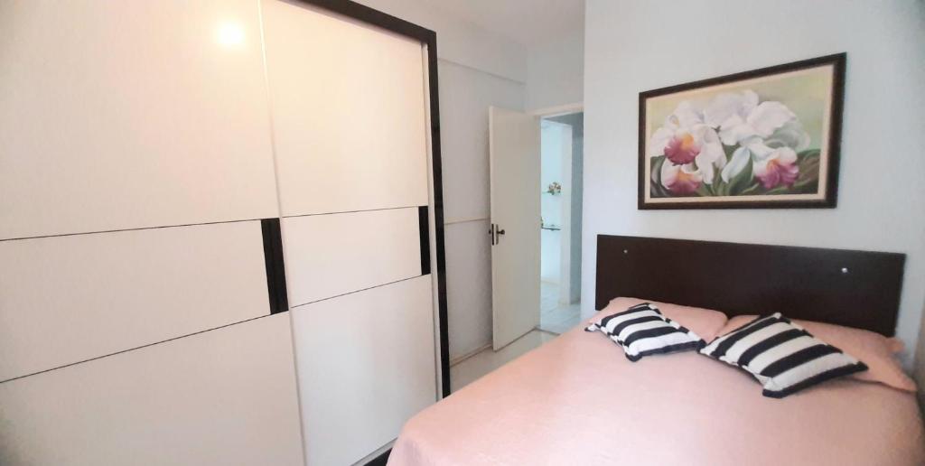 ein Schlafzimmer mit einem Bett und einem großen weißen Schrank in der Unterkunft Apartamento Aconchego na Praia da Costa in Vila Velha