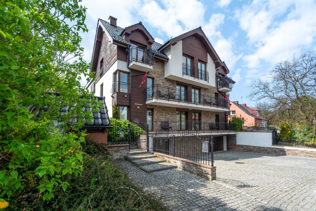 Rezydencja Wind Rose - luxury ApartHotel Gdansk في غدانسك: منزل قديم وامامه سياج