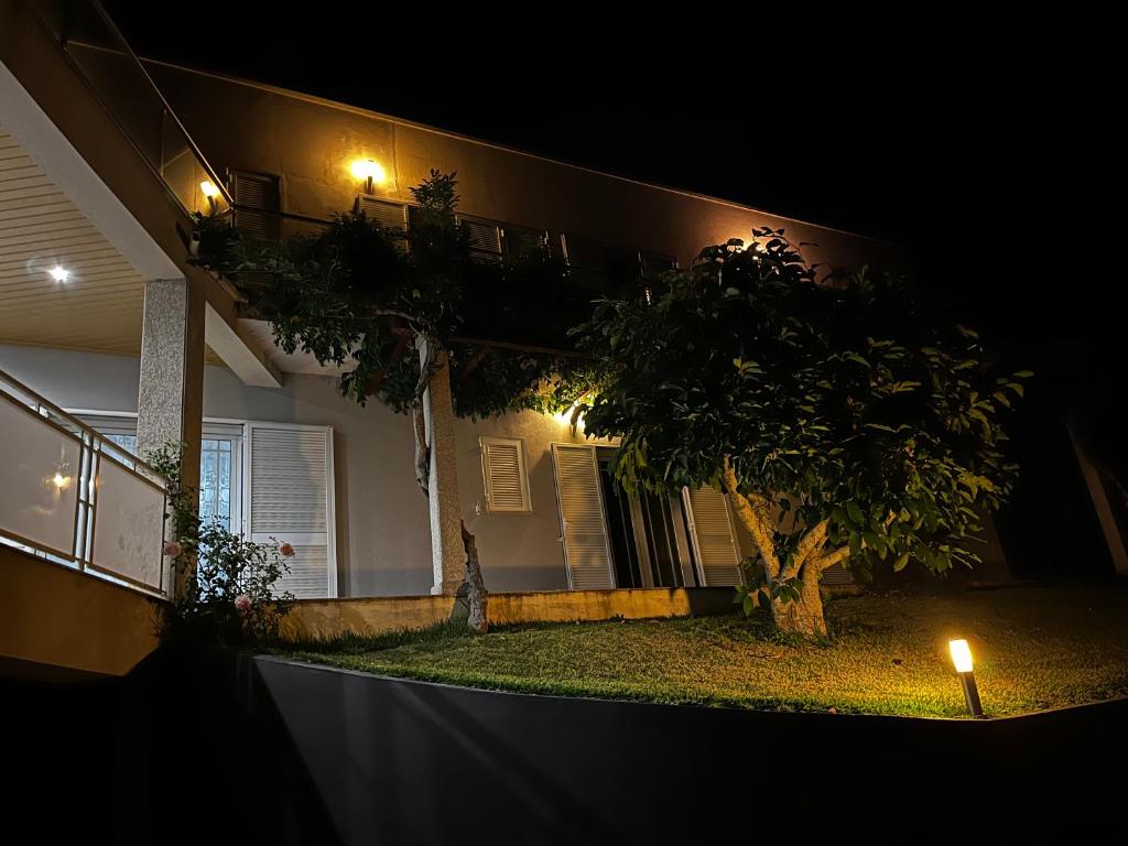 uma casa com uma árvore em frente à noite em Casa do Eirô em Resende