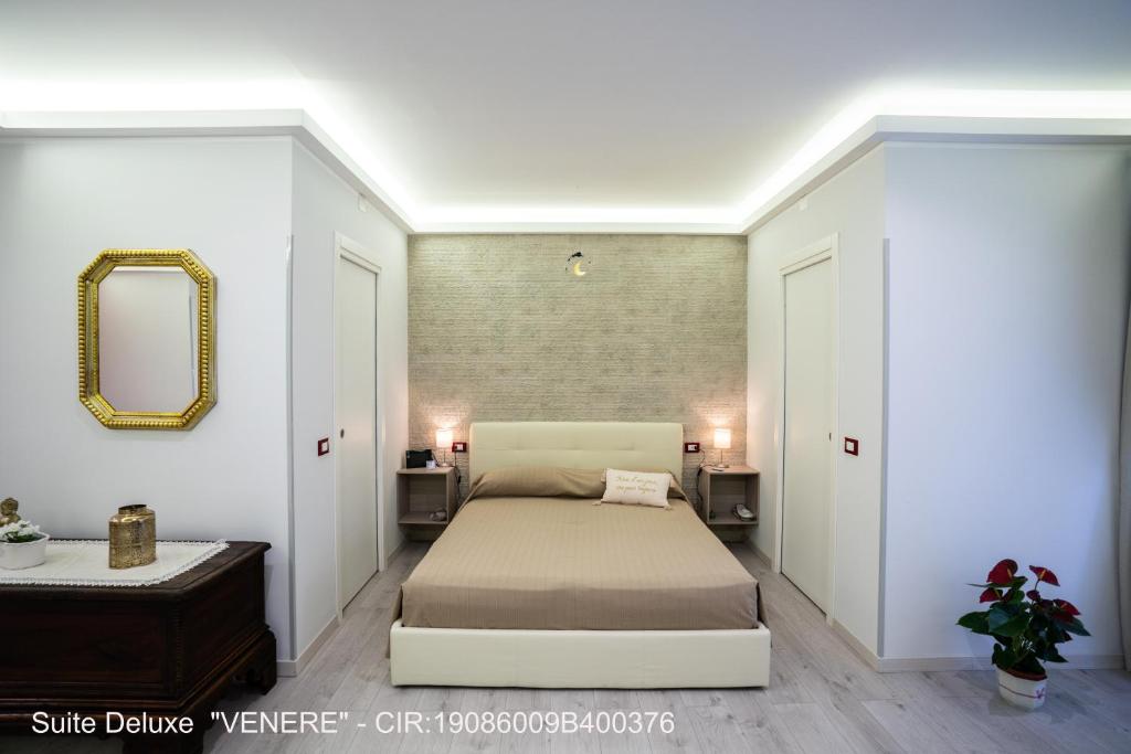 Schlafzimmer mit einem Bett, einem Spiegel und einem Tisch in der Unterkunft ROCCA DI CERERE Self Check-in Apartments in Enna