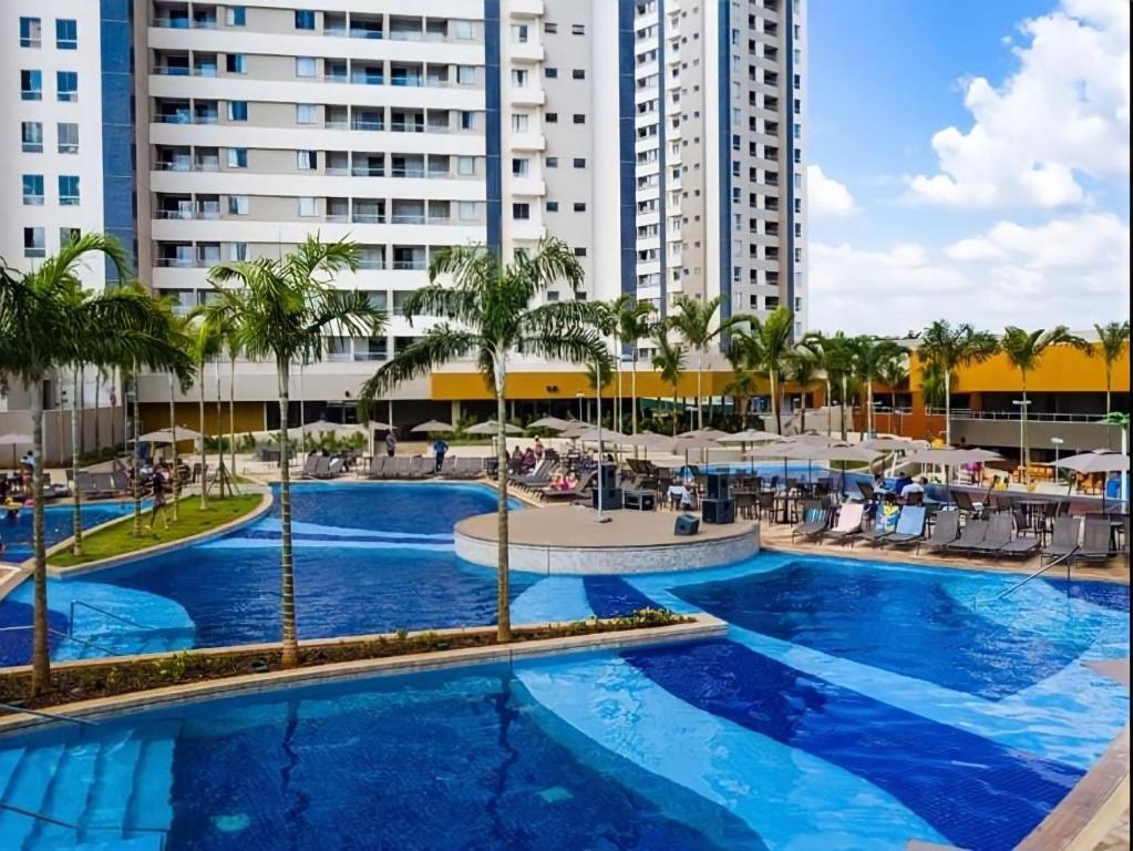 una grande piscina con palme e edifici di Apartamento dentro de resort próximo do Thermas dos Laranjais a Olímpia
