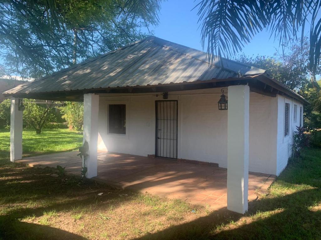 una pequeña casa blanca con una puerta en un patio en Paty house en Paso de la Patria