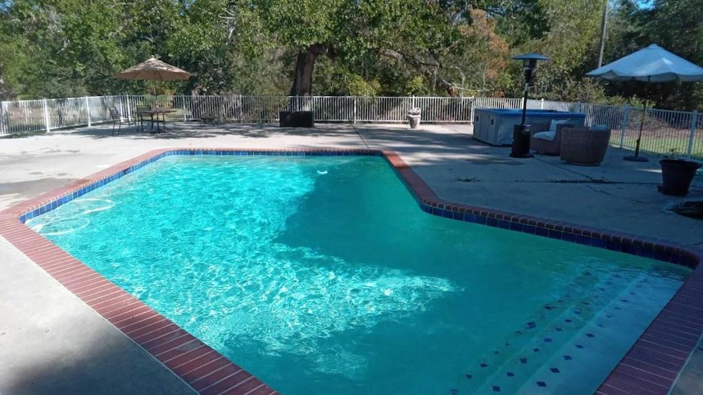 una piscina de agua azul en un patio en 10 beds 5 baths 24 acre Lake Property minutes The Woodlands TX, en Magnolia