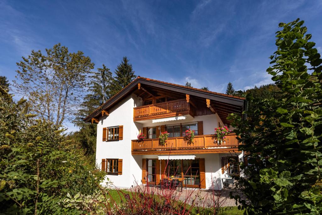 une maison blanche avec un balcon et des arbres dans l'établissement Ferienwohnungen Manger, à Schönau am Königssee