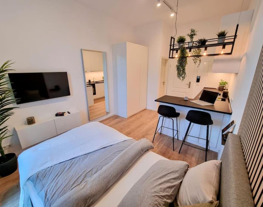 a bedroom with a bed and a desk with a laptop at Modernes Apartment Karlsruhe in Karlsruhe