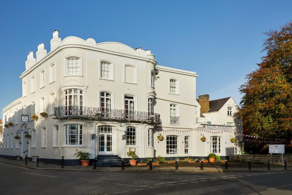 biały budynek z balkonem przy ulicy w obiekcie The Royal Adelaide Hotel w mieście Windsor