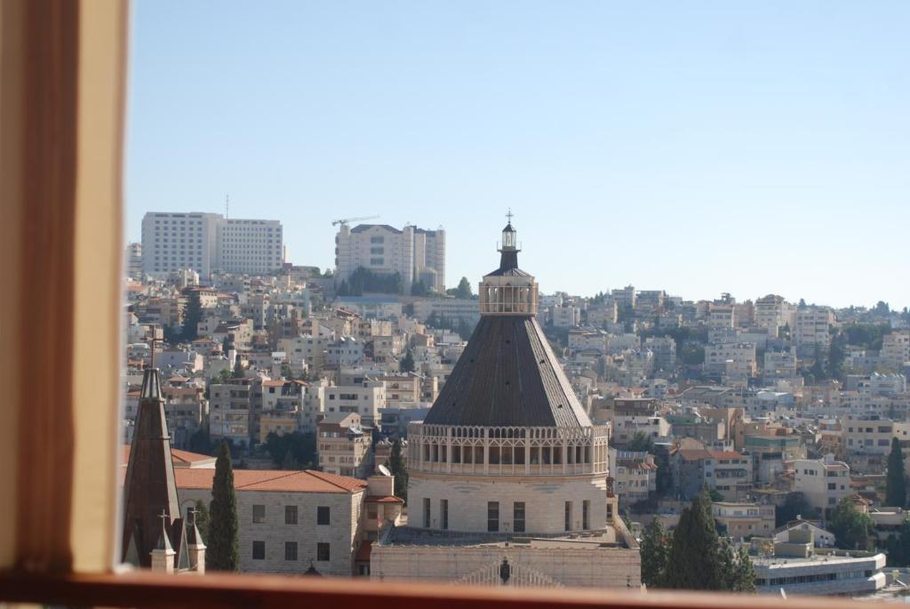 een raam met uitzicht op de stad bij Seedi Yousef Hostel & Cafe in Nazareth