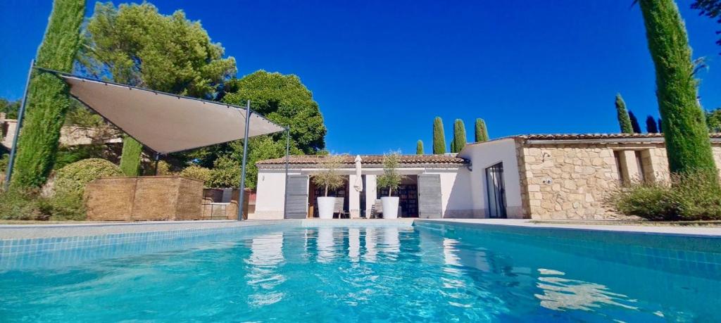 a swimming pool in front of a villa at LASUITE Domaine Bertuli, heated Pool, Aircon in Oppède