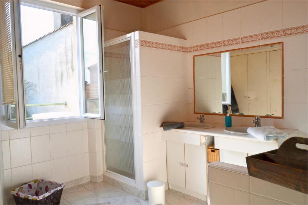 a bathroom with a sink and a mirror and a window at Pavillon de 4 couchages, très calme, proche centre ville in Albi