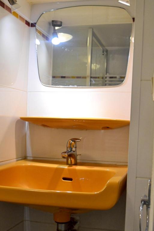 a bathroom with a yellow sink and a mirror at Pavillon de 4 couchages, très calme, proche centre ville in Albi