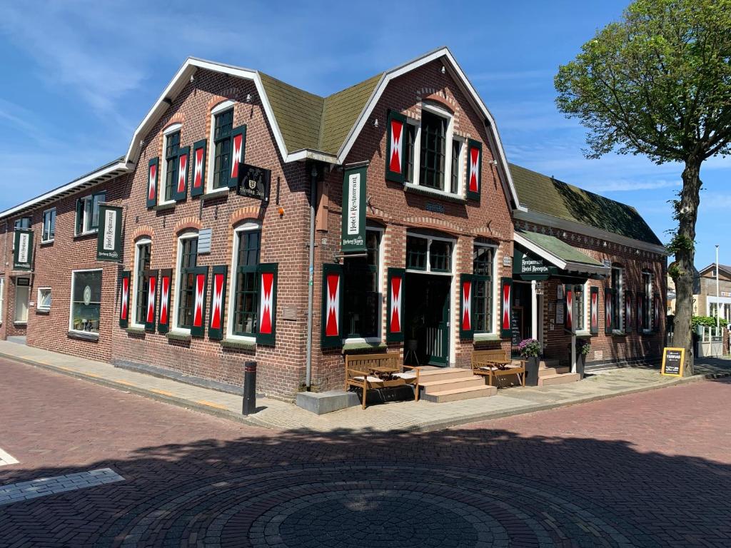 a large brick building with red shutters on a street at Herberg Binnen in Egmond-Binnen