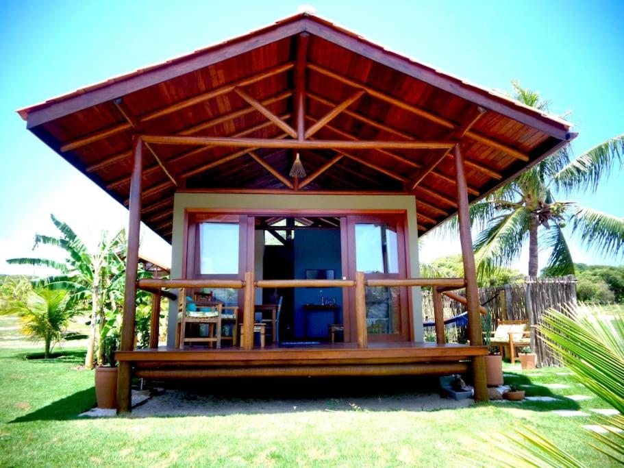 una pequeña casa con techo en la hierba en Villa Angelim - Natureza e Conforto Barra do Cunhaú en Barra do Cunhau